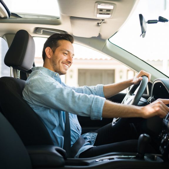 Attractive male driver using the GPS navigation map on the car