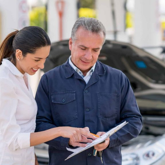 Woman talking to a mechanic about her car