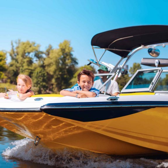 Cheerful little siblings enjoying view from boat bow